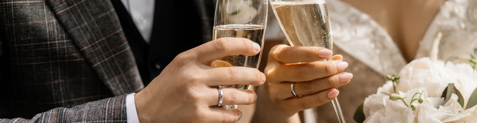 Manos de novios brindando con copas de champagne y ramo de flores en su boda laica en Perú