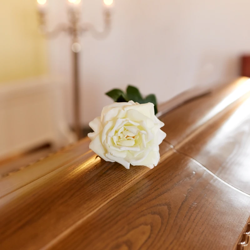 Ofrenda floral blanca sobre féretro en funeral humanista