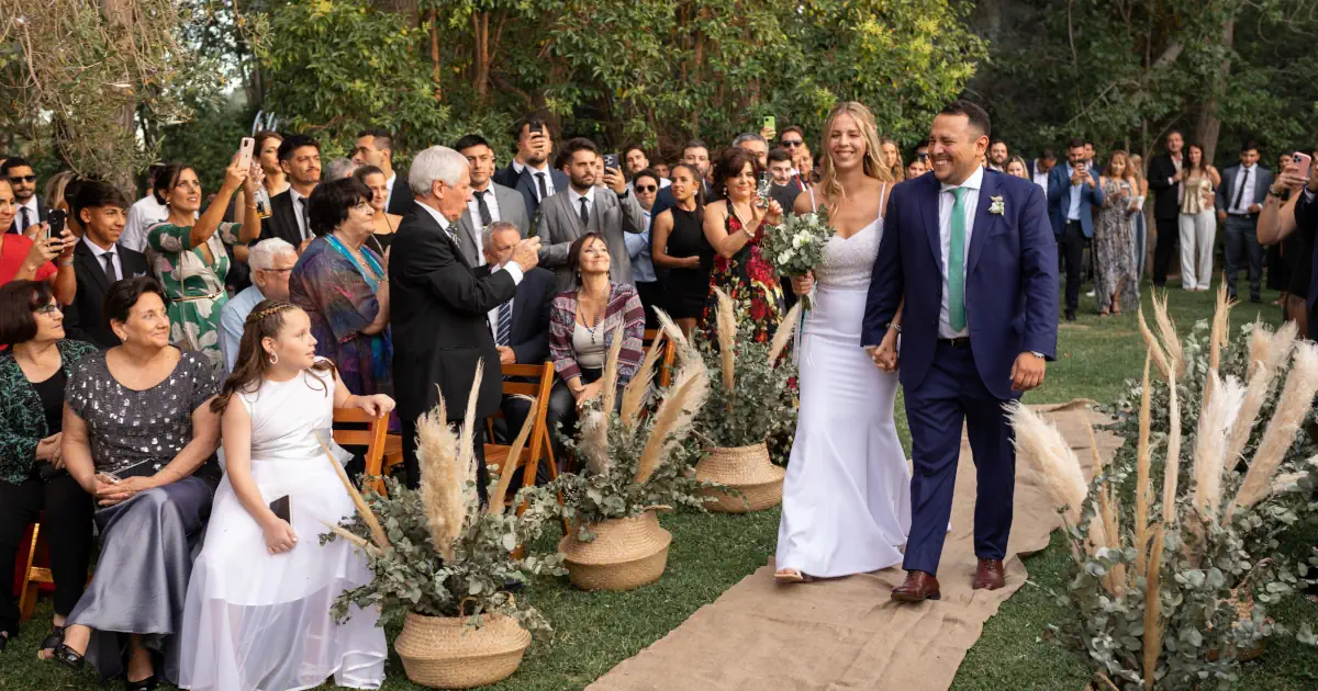 Pareja firmando simbólicamente su libreto de boda laica durante una ceremonia al aire libre