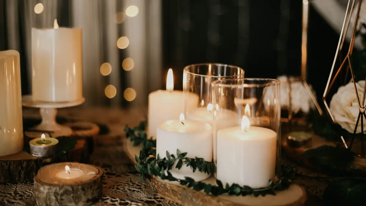 Mesa de conmemoración con una vela encendida, flores blancas y retrato en una despedida humanista retrospectiva