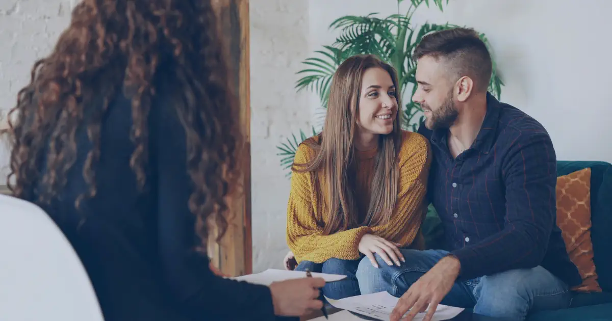 Celebrante humanista reunido con una pareja planificando los rituales de su boda
