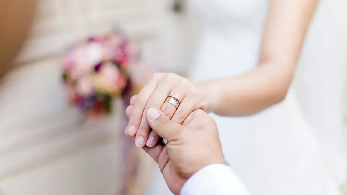 Pareja tomándose de las manos durante el intercambio de votos en una ceremonia humanista al aire libre